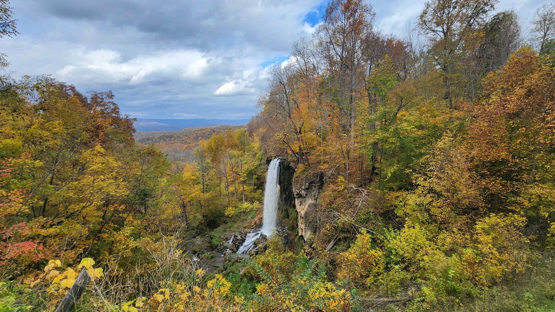 Falling Spring Falls cascading from a rocky ledge amid autumn foliage