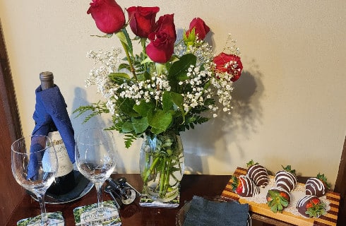 Bottle of wine with 2 glasses, bouquet of red roses and 6 chocolate covered strawberries