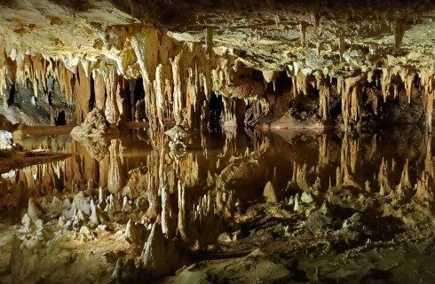 Dark cavern full of hanging stalagmites