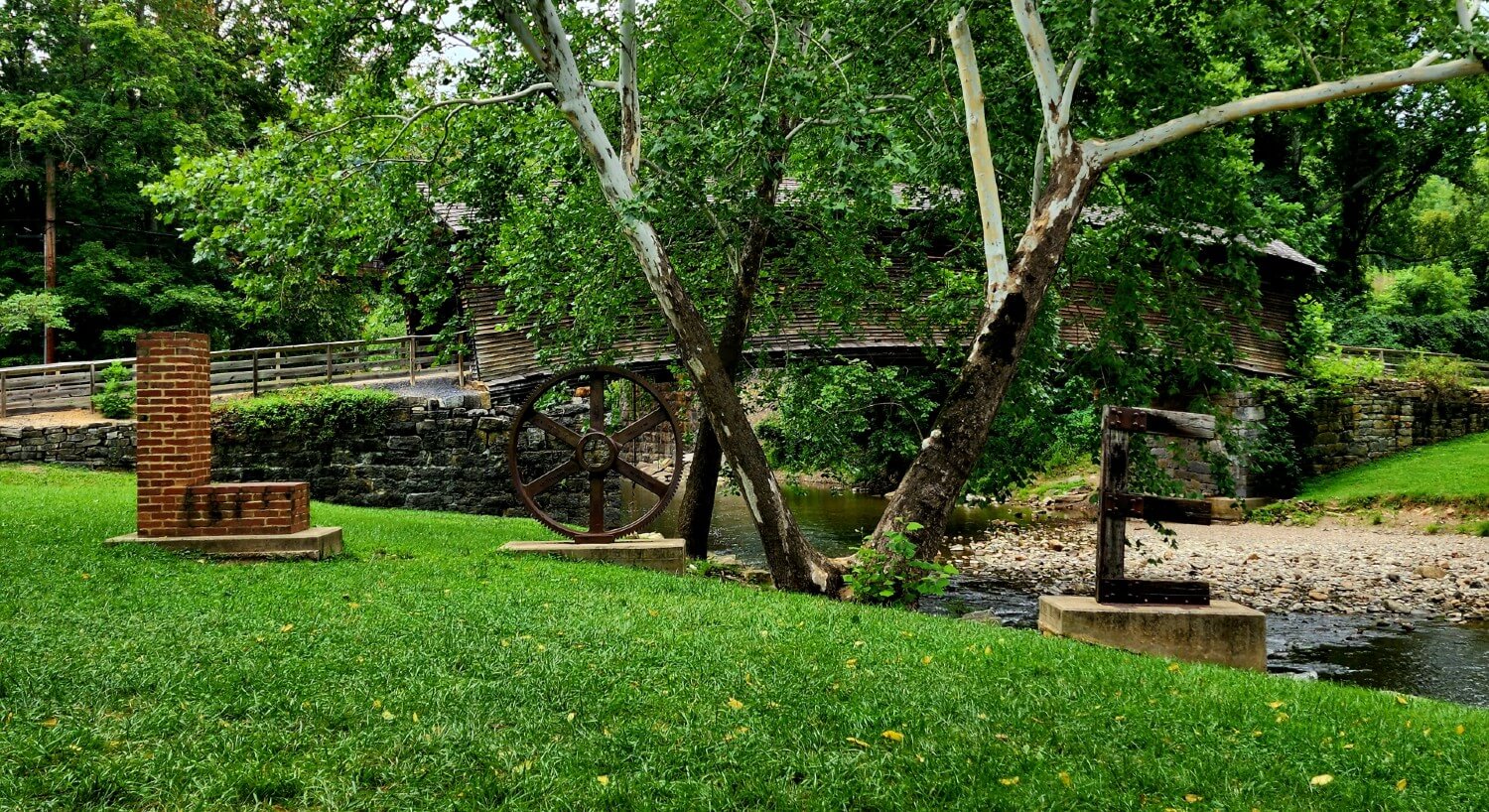 Small river with walking bride surrounded by trees and decorative letters spelling out LOVE